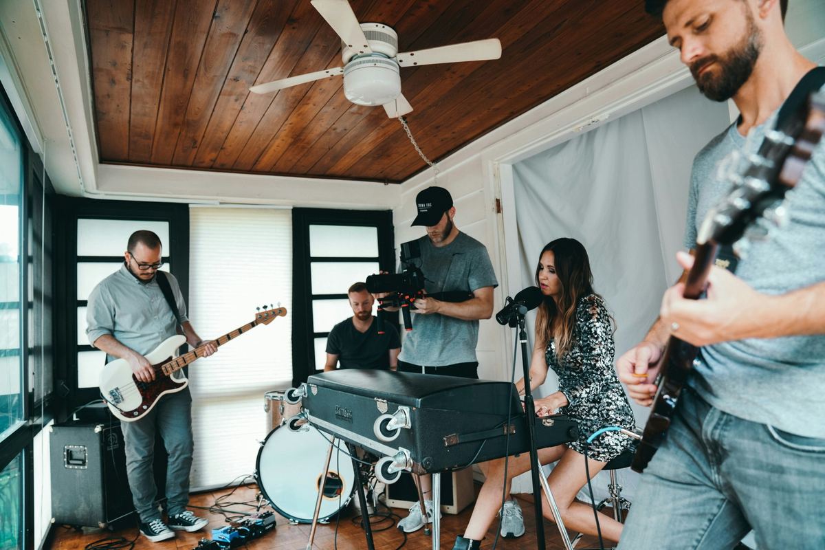 Band performing while a cameraman films a music video