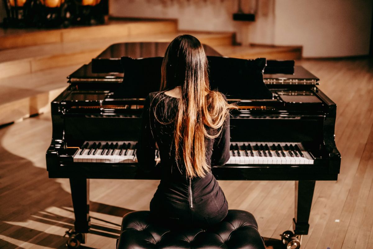 Pianist playing a grand piano at a live recital
